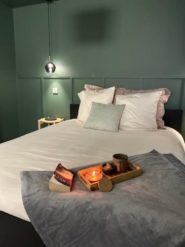 - un lit avec un plateau avec une bougie dans l'établissement appartement balnéo-centre ville et parking, à Moulins
