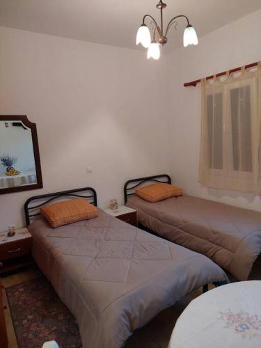 1 dormitorio con 2 camas y lámpara de araña en Peaceful and quiet apartment., en Aliki