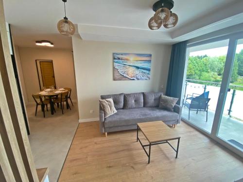 a living room with a couch and a table at Ogrodowa70 Apartment in Sztutowo