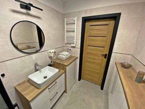 a bathroom with a sink and a mirror at Ogrodowa70 Apartment in Sztutowo