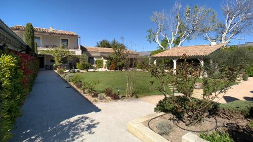 une maison avec une passerelle devant une cour dans l'établissement Residence Melody, à Saint-Rémy-de-Provence