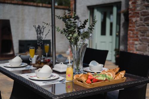 a table with a tray of food and a vase of flowers at Tranquil Rustic Cottage in Dromore