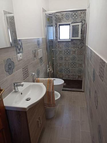 a bathroom with a sink and a toilet at Bilocale per vacanze a Vada in Vada