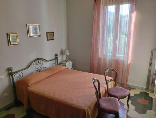 a bedroom with a bed and a window and two chairs at Bilocale per vacanze a Vada in Vada