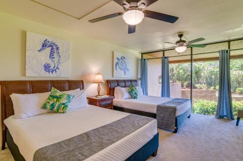 a bedroom with two beds and a ceiling fan at Kahana Villa E111 in Kahana
