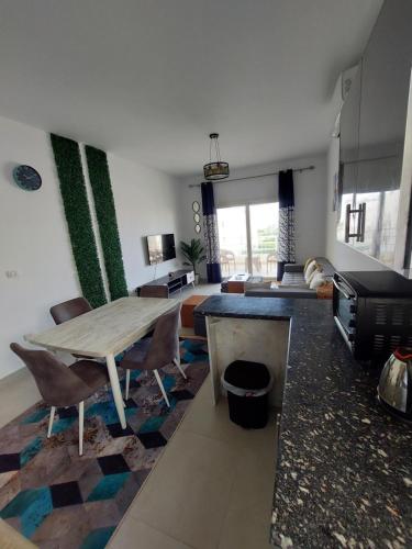 sala de estar con mesa y sofá en Amwaj Resort امواج الساحل الشمالى 2 نوم 2 حمام, en El Alamein