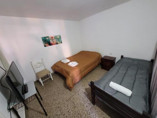 Un dormitorio con una cama y un televisor. en Hotel Belgrano, en Villa Carlos Paz