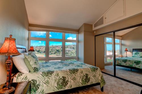 a bedroom with a bed and a large window at Kahana Villa E706 in Kahana