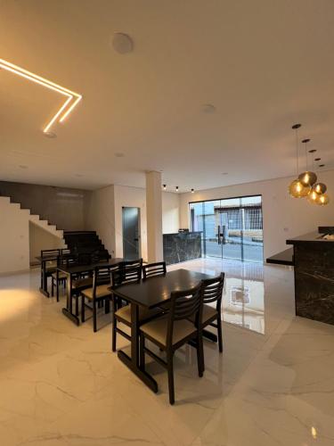 a dining room with tables and chairs and a staircase at Hotel Pousada Colliseu in Aparecida