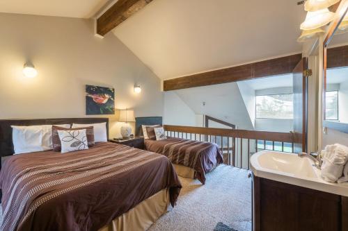 a bedroom with two beds and a sink and a tub at Powder Point Condos by Lespri Property Management in Park City