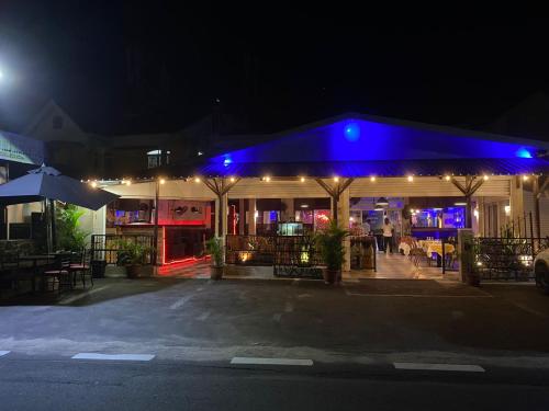 un restaurant éclairé la nuit avec des lumières bleues dans l'établissement Symon Belle Mare Lodge, à Belle Mare