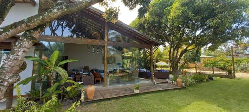 una casa con terraza de madera en un patio en Lá em Casa - Guest House, en Barra Grande