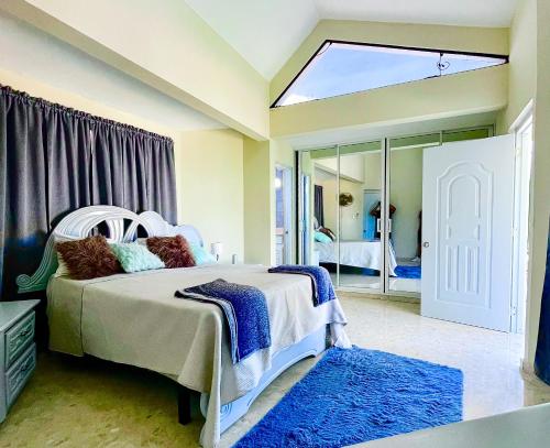 a bedroom with a white bed and a mirror at Refugio Encantador in Santo Domingo
