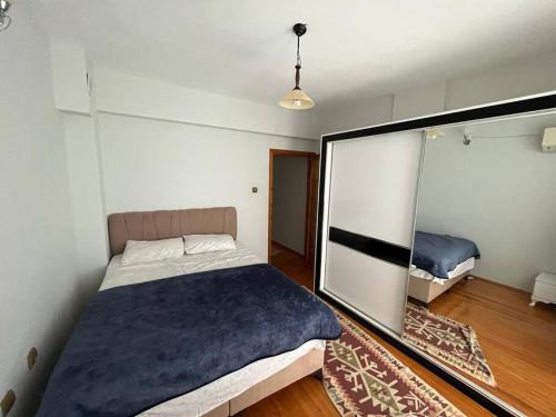 1 dormitorio con 1 cama grande y espejo en Alaçatıda bahçeli müstakil ev, en Alacati