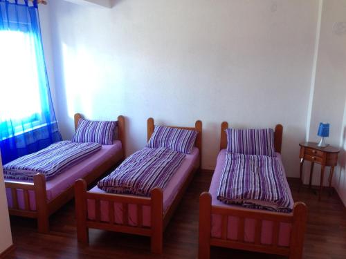 a room with three beds and a window at Apartment Ana Marija in Mavrovo