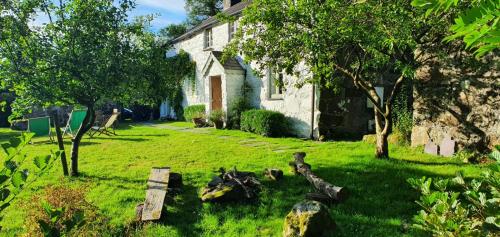 a yard of a house with a bench in the grass at Gesail Barn and Farmhouse in Machynlleth