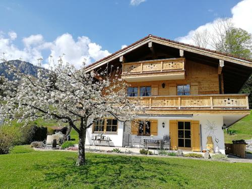 a large wooden house with a tree in front of it at Ferienwohnung Springl in Schönau am Königssee