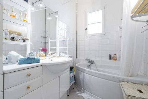 une salle de bain blanche avec une baignoire et un lavabo dans l'établissement Nice Сentre 3 pièces 80m2 AC, à Nice