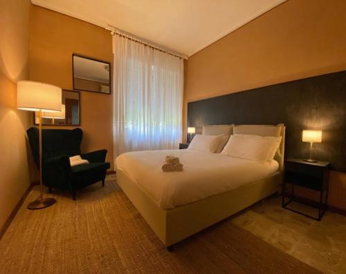 Habitación de hotel con cama y silla en Alta Langa Suites en Cortemilia