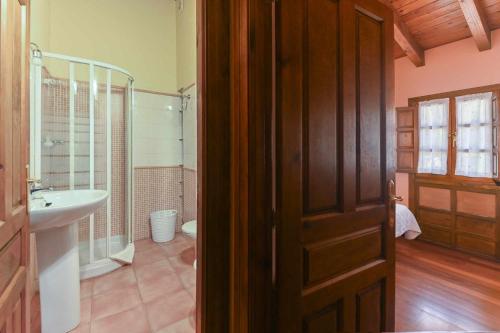 a bathroom with a shower and a sink and a door at Apartamentos Rurales El Cuetu in Picones