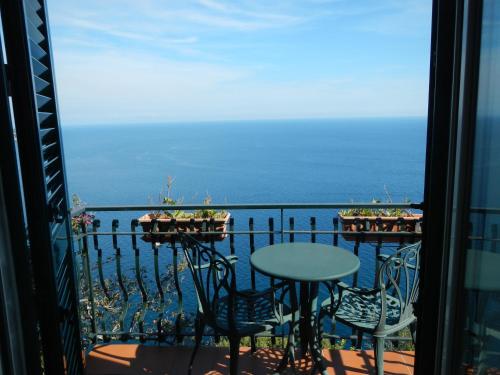 
a dining room table with a balcony overlooking the ocean at Casa Bouganville in Positano
