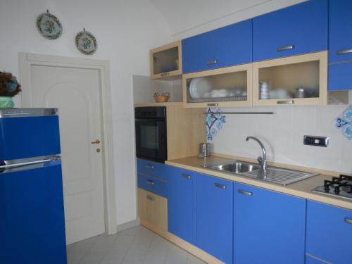 una cocina con armarios azules y fregadero en Casa Bouganville, en Positano