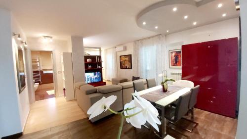 een eetkamer en een woonkamer met een tafel en stoelen bij Bella Vista Apartments in Umag