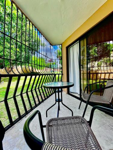 a balcony with a table and chairs and windows at Refugio Encantador in Santo Domingo