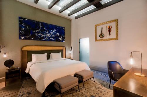 a bedroom with a large bed and a desk and chairs at Casona 142 Orizaba, Part of Curamoria Collection in Orizaba
