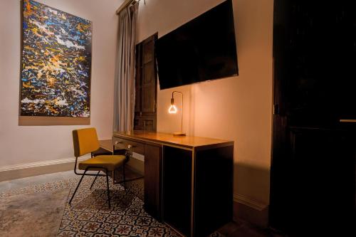 a room with a desk with a lamp and a painting at Casona 142 Hotel Boutique Orizaba in Orizaba