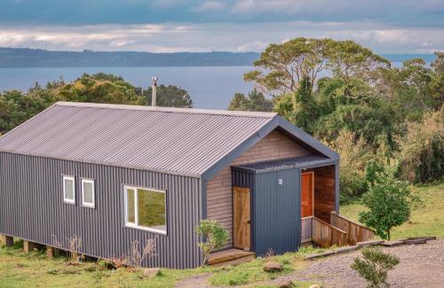 a tiny house on a hill with a view of the water at Ave Lodge Frutillar in Frutillar