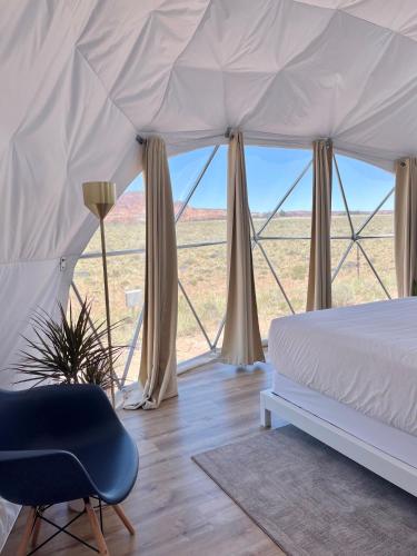 a bedroom with a bed and a chair in a tent at Skyview Hotel in Torrey