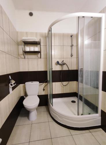 uma casa de banho com um WC e uma cabina de duche em vidro. em Chata Gatterhof em Banská Štiavnica