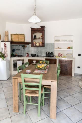 a kitchen with a wooden table and green chairs at Nel cuore del centro storico di Maratea in Maratea