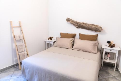 um quarto com uma cama com lençóis brancos e uma escada em Nel cuore del centro storico di Maratea em Maratea