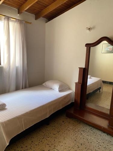 a bedroom with two beds and a mirror at CASA FAMILIAR AMPLIA MUY FRESCA in Medellín