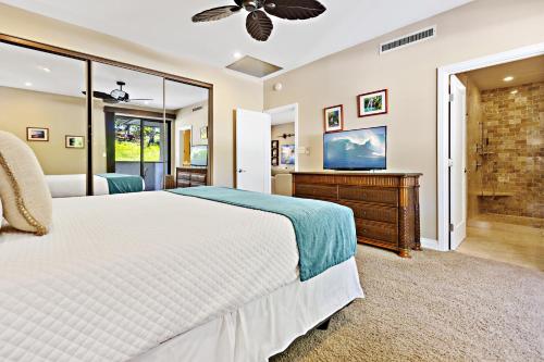 una camera con un grande letto e una televisione di Kapalua Golf Villa 12V 1 a Kahana
