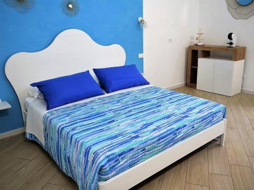 a bedroom with a bed with blue walls at Vico 18 in Gaeta