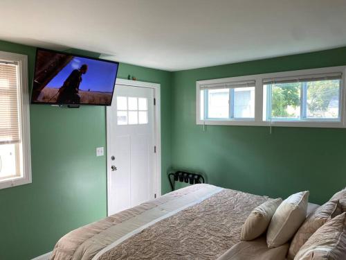a bedroom with a bed and a flat screen tv on the wall at Sunny One Bedroom in Historic Downtown Dover in Dover