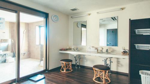 a bathroom with two stools and a sink and a tub at Kuretake-Inn Kikugawa I.C. in Kikugawa