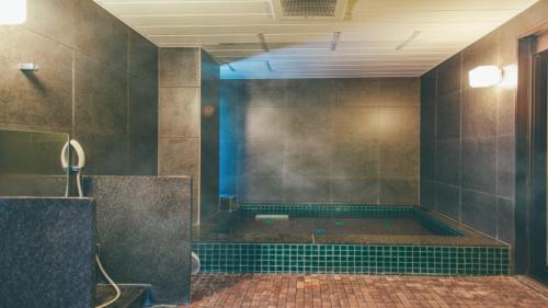 an empty bathroom with a shower with a tub at Kuretake-Inn Kikugawa I.C. in Kikugawa