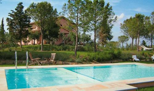 a swimming pool in front of a house at Villa Val delle Vigne in Diaccialone