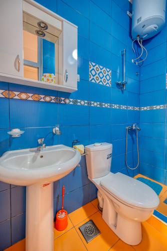 a blue bathroom with a toilet and a sink at Apartments Vujosevic in Tivat