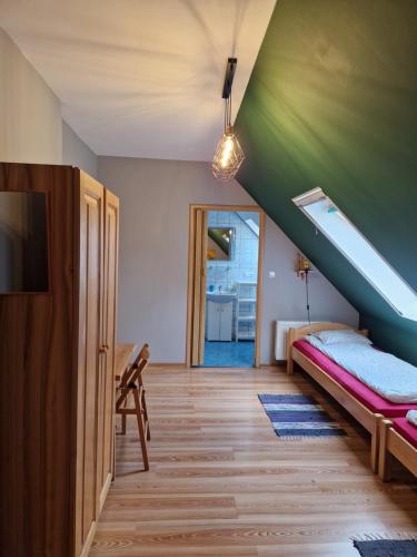 Zimmer mit einem Bett, einem TV und einer Treppe in der Unterkunft Sosnowy Młodnik in Płaska