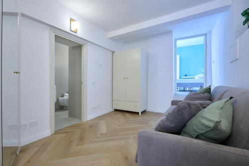 a living room with a couch and a bathroom at CAMERANOAPARTMENTS - L'Angolo della Piazza in Camerano