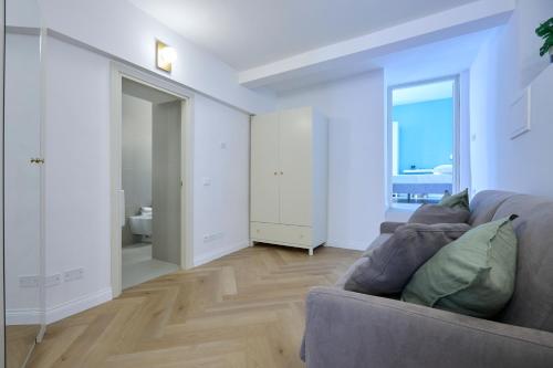ein Wohnzimmer mit einem Sofa und einem Badezimmer in der Unterkunft CAMERANOAPARTMENTS - L'ANGOLO DELLA PIAZZA in Camerano