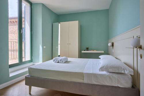 a bedroom with a large bed with two towels on it at CAMERANOAPARTMENTS - L'Angolo della Piazza in Camerano