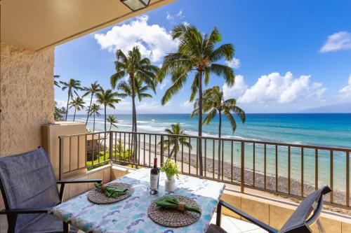 a table on a balcony with a view of the ocean at Paki Maui 405 in Honokowai