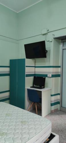 Schlafzimmer mit einem Bett und einem Schreibtisch mit einem Laptop in der Unterkunft Room Rome in Roccella Ionica