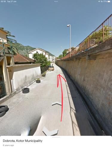 an empty street with a red arrow pointing to a wall at DC Apartment D in Kotor